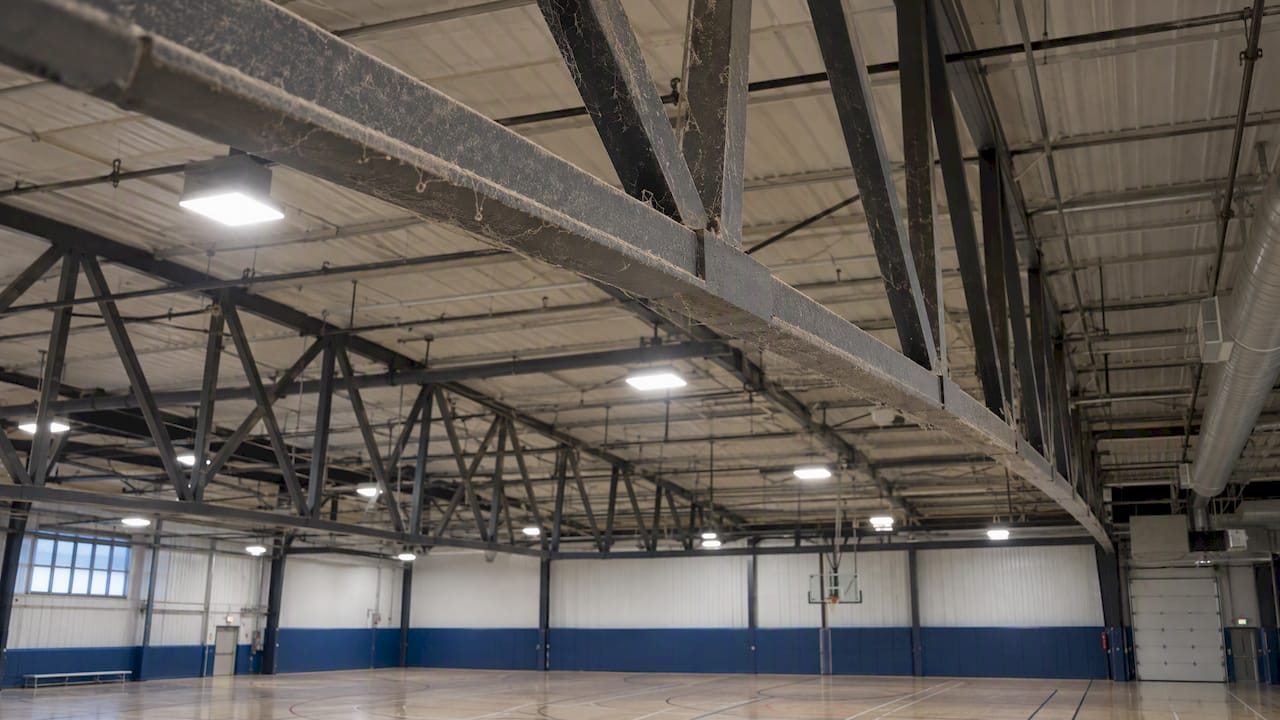Dusty arena trusses above indoor court